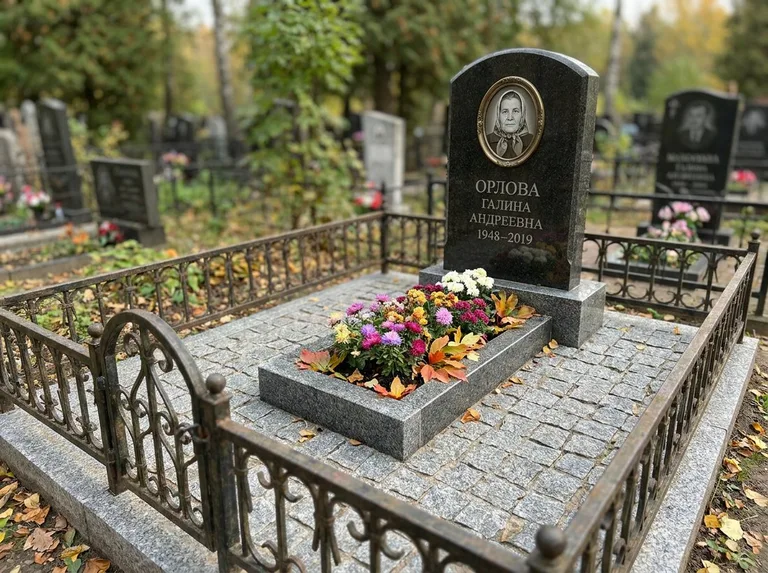 Благоустроенное захоронение с гранитной плиткой, оградой и цветником в Екатеринбурге
