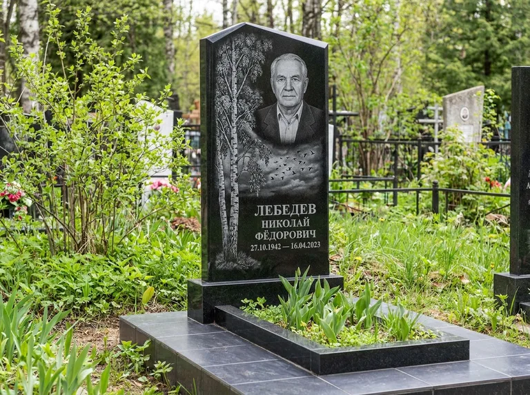 Памятник с гравировкой берёзы: вертикальная стела со скошенным верхом — берёза и стая птиц в небе, гранитный цоколь с тёмной плиткой, работа «Лебедев» в Екатеринбурге