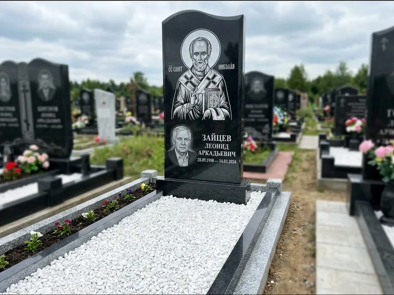 Памятник с гравировкой иконы: стела с крестообразным навершием — икона в резной рамке-киоте, газон без ограды, стриженая трава, работа «Раевская» в Екатеринбурге