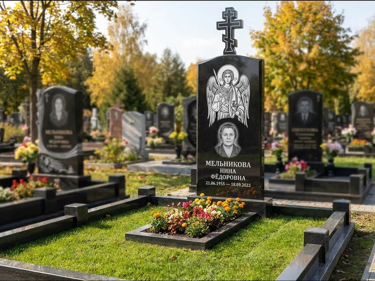 Памятник с гравировкой иконы: округлая стела-медальон с ликом — гравировка Богородицы «Семистрельная», луговые травы и полевые цветы за участком, работа «Гущин» в Екатеринбурге