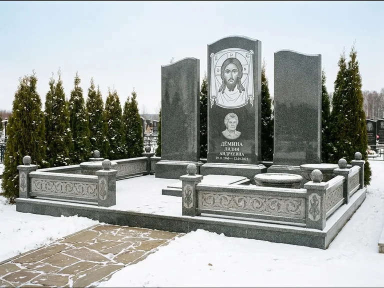 Памятник с гравировкой иконы: узкая вертикальная стела-пилон с ликом — икона в резной рамке-киоте, открытая лужайка без ограды, работа «Одинцов» в Екатеринбурге