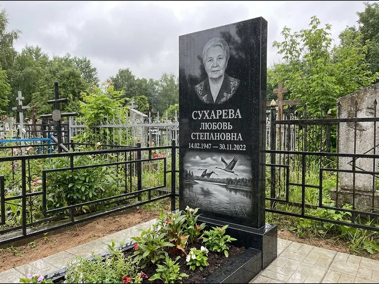 Памятник с гравировкой журавлей — гравировка пары журавлей над гладью озера в нижней части, работа «Сухарева» в Екатеринбурге